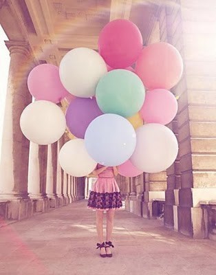 girl holding balloons, her face obscured